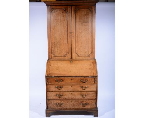 Georgian oak bureau bookcase, cavetto moulded cornice, the upper section with panelled doors enclosing adjustable shelves, th