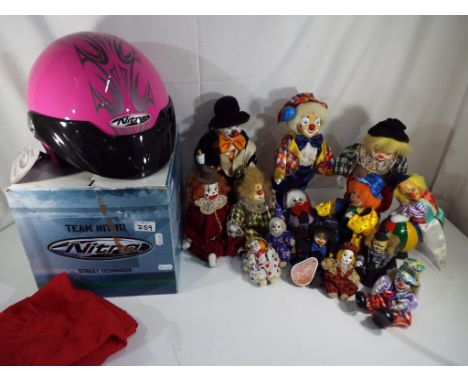 A quantity of approximately twelve ceramic and china headed clowns and a Team Nitro Street Technique helmet with material bag