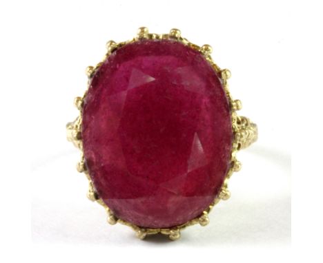 A 9ct yellow gold ring set with a large oval cut ruby, (M.5).