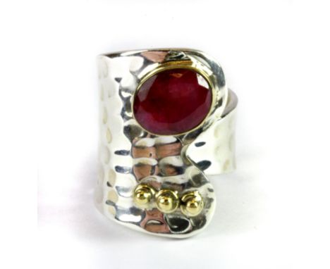 A 925 silver adjustable ring set with an oval cut ruby.