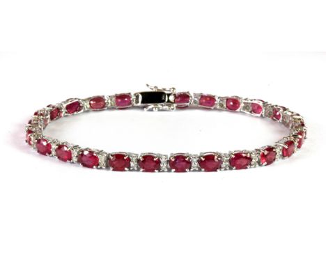 An 18ct white gold (stamped 18k) ruby and diamond tennis bracelet, L. 18cm.