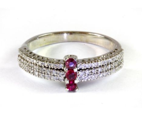 A white metal (tested high carat gold) ruby and diamond set ring, (O).