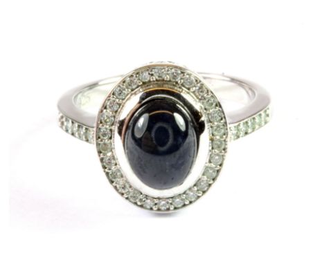 A 925 silver halo ring set with a cabochon cut sapphire and white stones, (K).