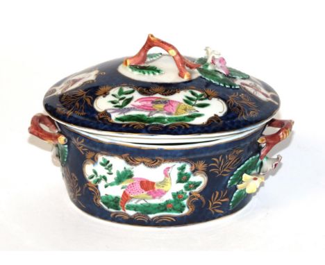 A Worcester butter tub and cover, of oval form, with twiggy floral handles, decorated with panels of exotic birds and insects