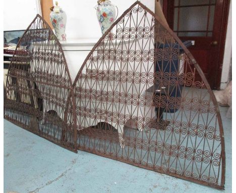 INDIAN GRILLS, a pair, rusted iron, of pointed arch form, 151cm H x 72cm. (2)