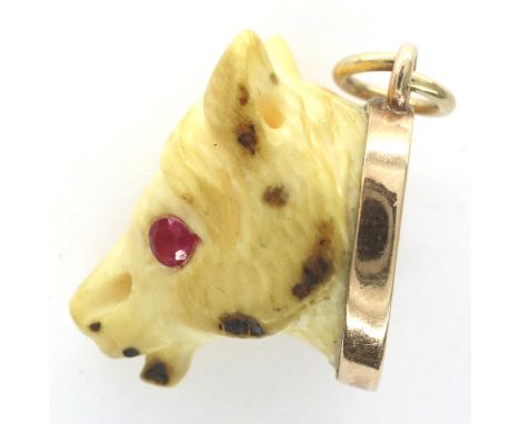 A Victorian carved bone horse pendant, the beast having ruby set eyes and mounted in rose gold (unmarked), L: 25 mm, 3.7g. P&