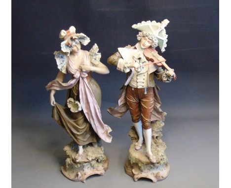  A pair of large Bohemian figures of a gent playing a violin and his lady companion, classically dressed, standing on rock mo