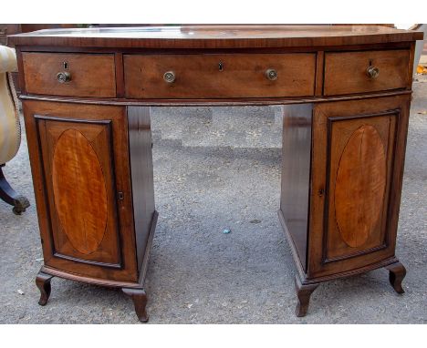 A 19th Century mahogany bow fronted kneehole desk, having three drawers and two doors, raised on splayed bracket feet, 81cm h