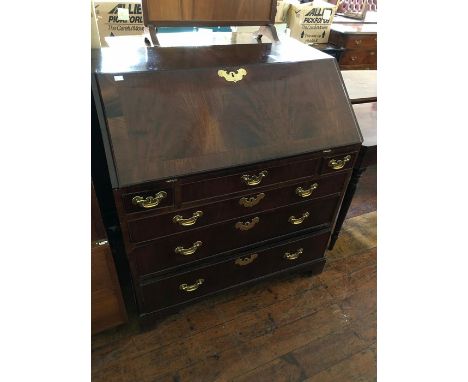 A George III mahogany bureau, the fall front enclosing a fitted interior, with drawers and pigeon holes, the base section wit