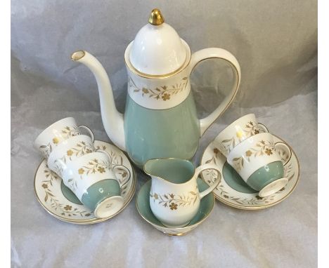 A Susie Cooper coffee set, comprising pot, five cups and saucers, milk jug and stand, and a sugar bowl, in green and white wi