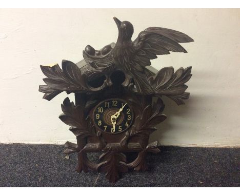 An early 20th Century Black Forest Cuckoo Clock, carved detachable pediment (af), complete with two weights and pendulum, etc