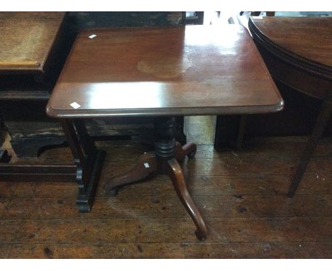 A George III mahogany rectangular tilt top table, circa 1820, raised on a turned column on a tripod cabriole legs on scrolled