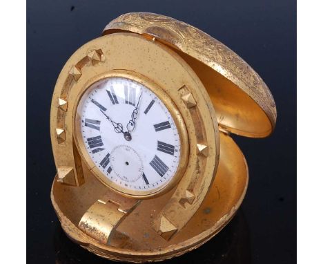 An early 20th century travel clock, the oval gilt metal case engraved to the cover with a horse and jockey, the underside eng