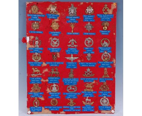 A collection of assorted cap badges to include Royal Army Service Corps, East Surrey Regiment, King Edward's Horse, Royal Ele