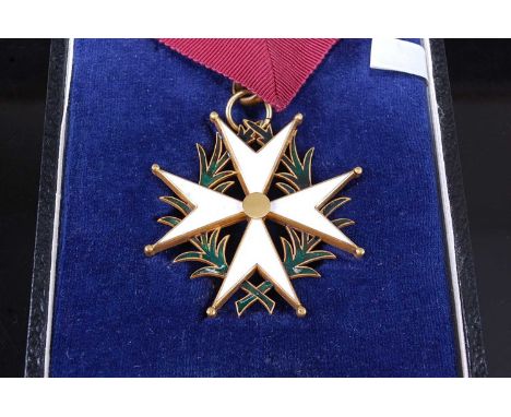 A Commonwealth Order of St John, the white enamelled Maltese cross over green enamel wreath, cased, together with a silver pl