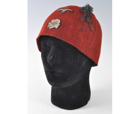 A German Waffen SS Handschar Division fez, with black tassle and cloth badges. We believe this item to be a reenactors / film