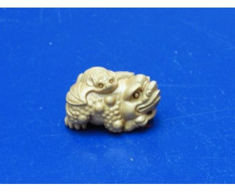 A small carved wooden Fou Dog form netsuke