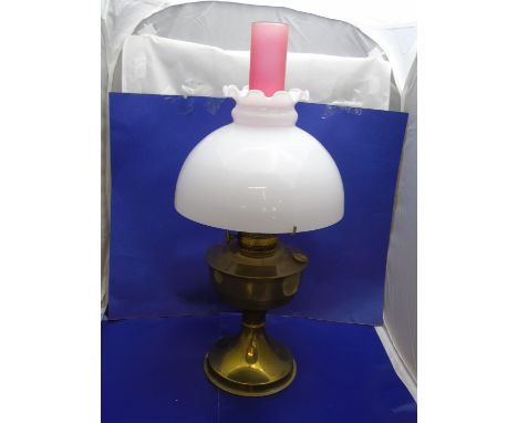 A brass based oil lamp with pink chimney 55cm tall 