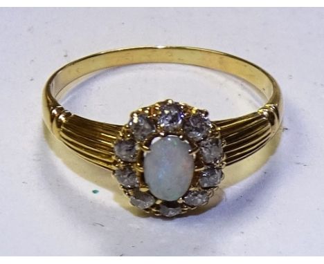 A yellow metal opal and diamond dress ring, the central oval cabachon opal surrounded by 10 old cut diamonds, approx 0.30ct i