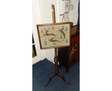 A Victorian mahogany adjustable pole screen, with needlepoint panel raised on turned column and carved tripod supports with a