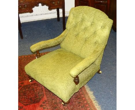 A 19th century mahogany low armchair in the style of Howard & Sons, upholstered in green buttonback fabric, raised on turned 