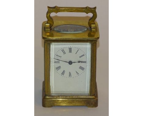 A brass carriage clock, the white enamel dial with Roman numerals, 15cm high