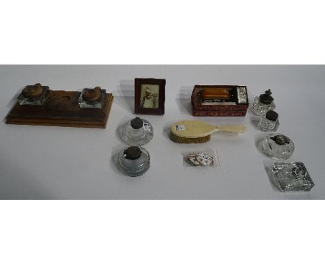 A collection of various glass inkwells, two within wooden base holders, together with an ivory hairbrush, a collection of thr