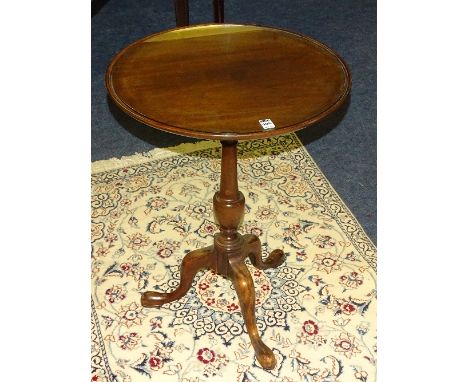 A George III style mahogany tea table, the circular top raised on turned column and tripod supports with pad foot, 69cm high 