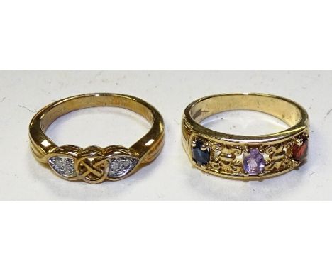 A 9ct gold ruby, amethyst and sapphire ring, the three oval cut stones interspersed by fleur de lys decoration, stamped 375, 