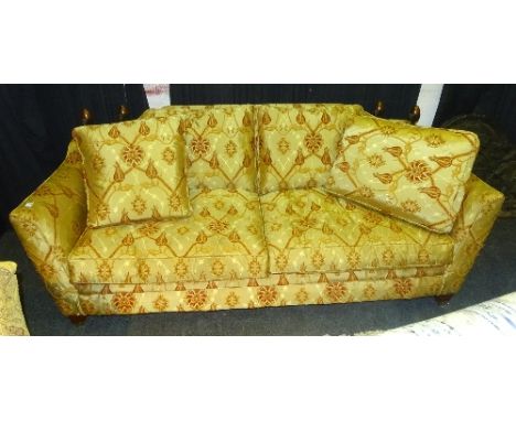 A modern three seater sofa, upholstered in Arts & Crafts style damask with flowerhead decoration and wooden finials to top of