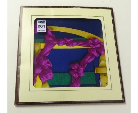 A silk Hermes scarf, decorated with gold horse bits, bridles and stirrups on navy blue ground with green and pink ribbons, in