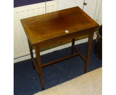 A vintage mahogany fold over card table, enclosing felt lined interior, raised on tapering supports, 70cm high 61.5cm wide x 