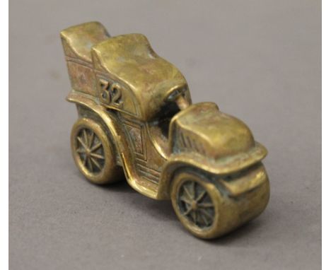 A brass vesta formed as a vintage car. 6 cm long.