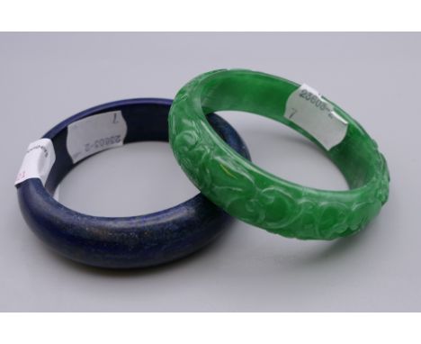 A Chinese carved jade bangle and another. The former 7.25 cm diameter.