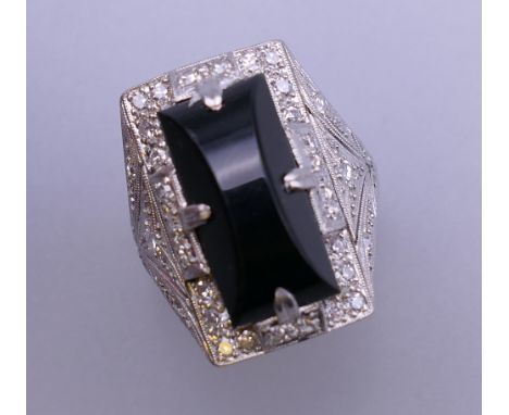 An Art Deco onyx and diamond white gold cocktail ring. Ring size N/O. 13.7 grammes total weight