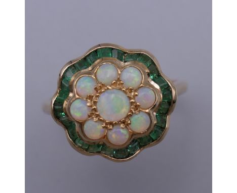 A 9 ct gold, opal and emerald ring. Ring size L/M. 2.6 grammes total weight.