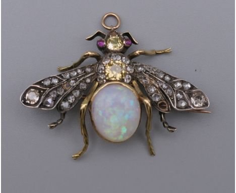 An unmarked gold diamond, opal and ruby brooch formed as a fly. 4.5 cm wide.  10.1 grammes total weight.