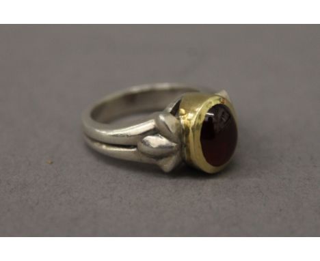 An unmarked gold and silver garnet ring.  Ring size L.