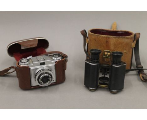 A cased set of binoculars and a Zeiss Ikon camera. The former 13 cm high.