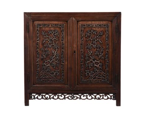 A CHINESE EXPORT HARDWOOD CABINET SECOND HALF 19TH CENTURY Carved with reeded borders to all sides, the interior with a shelf