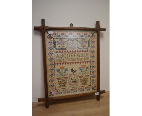 Early 20th Century, needlework, An alphabet sampler illustrated with vases of flowers, initials 'GA' with a cartouche surmoun