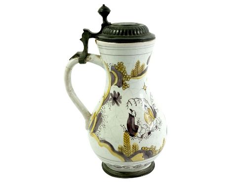 A German faience tankard, circa 1761, baluster form, yellow and manganese decorated, the metal lid embossed with a portrait m