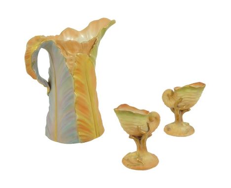 A Royal Worcester blush ivory leaf jug, together with two conch shell pedestal vases, green and puce marks, 21cm high (3)