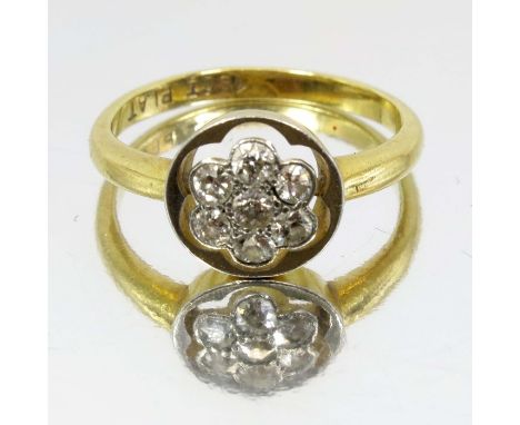 An 18 carat gold and diamond cluster ring, seven stones in the form of a flower, set in platinum, approx size J 1/2