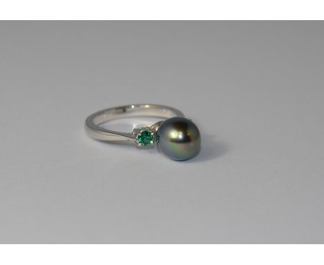 A 9ct. white gold three stone ring set with grey freshwater pearls and two synthetic emeralds. Size:N.  approx 3.7g