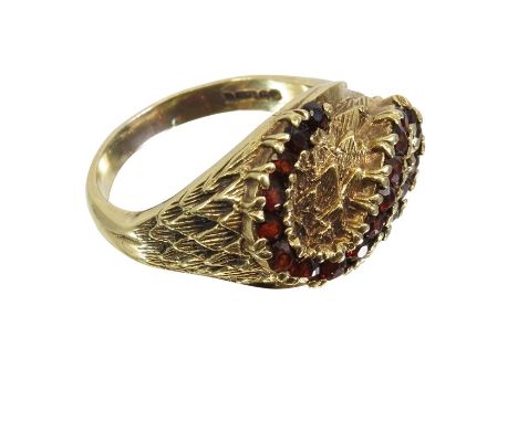 A 9 carat gold and garnet ring, relief moulded feather and S scroll design, 8.0g