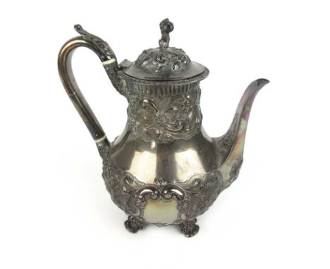 A Victorian silver teapot with embossed foliate and scrolling decoration and oriental figure finial. Hallmarked for London, 1