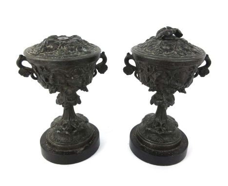 A pair of late 19th century spelter lidded garnitures with foliate decoration and slate bases. H. 21 cm CONDITION REPORT: One