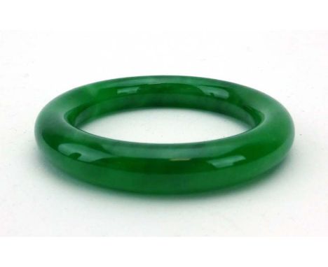 A green jade bangle, internal d. 5.8 cm