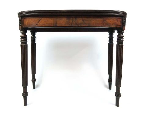 A Regency mahogany and ebony strung tea table, the fold over top supported on twin gate action on turned and reeded legs, h. 